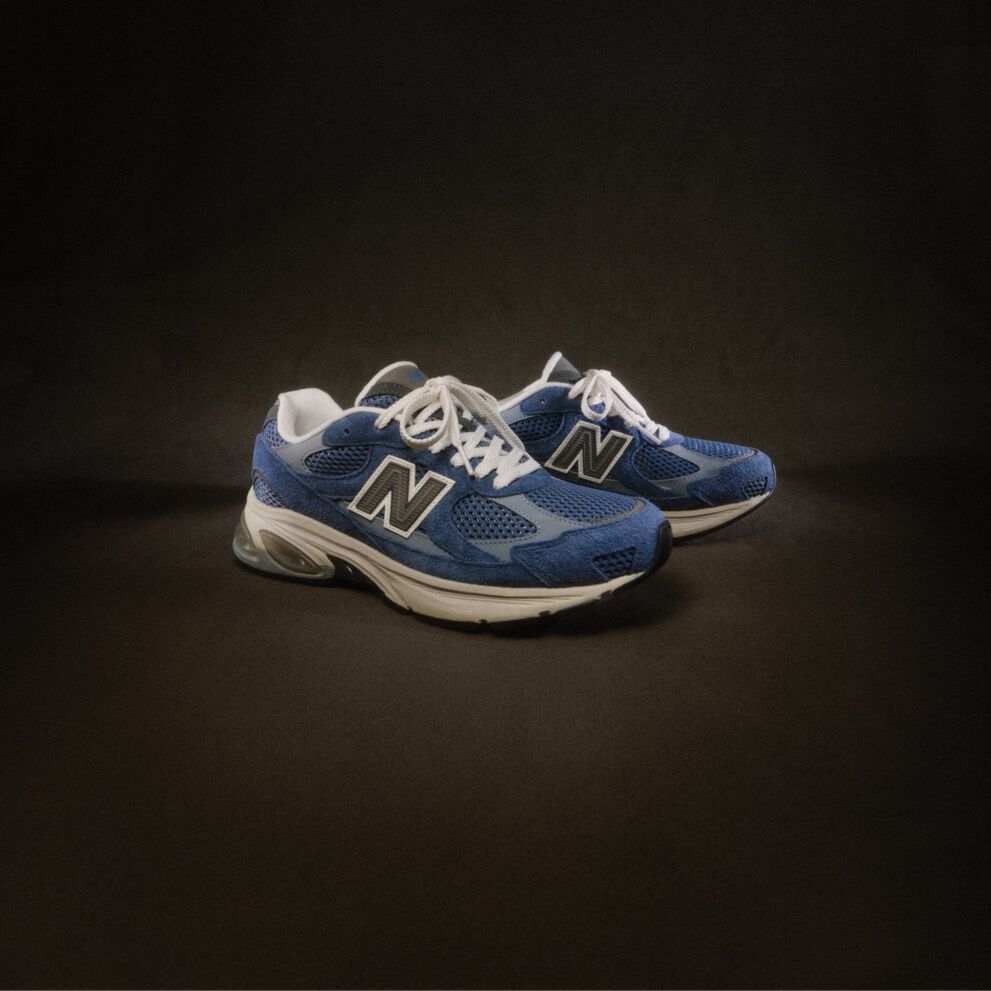 A blue shoe on a dark brown backdrop. 